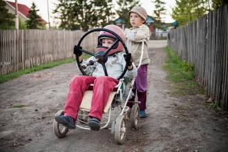 David Siemens (8) in the buggie with an old tractor steering wheel and his brother Jakob (5) are playing astronauts in the entrance of their house. There are seven children altogether in the Siemens family, and they are two of about 160 Mennonite-Children living in Solnzewka today. Solnzewka, May 2008.